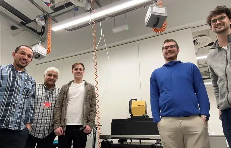 Staff from Cardiff University's Institute for Compound Semiconductors stand next to the newly installed CERES µAM Print System, alonside Riccardo Conte, Exaddon R&D engineer.